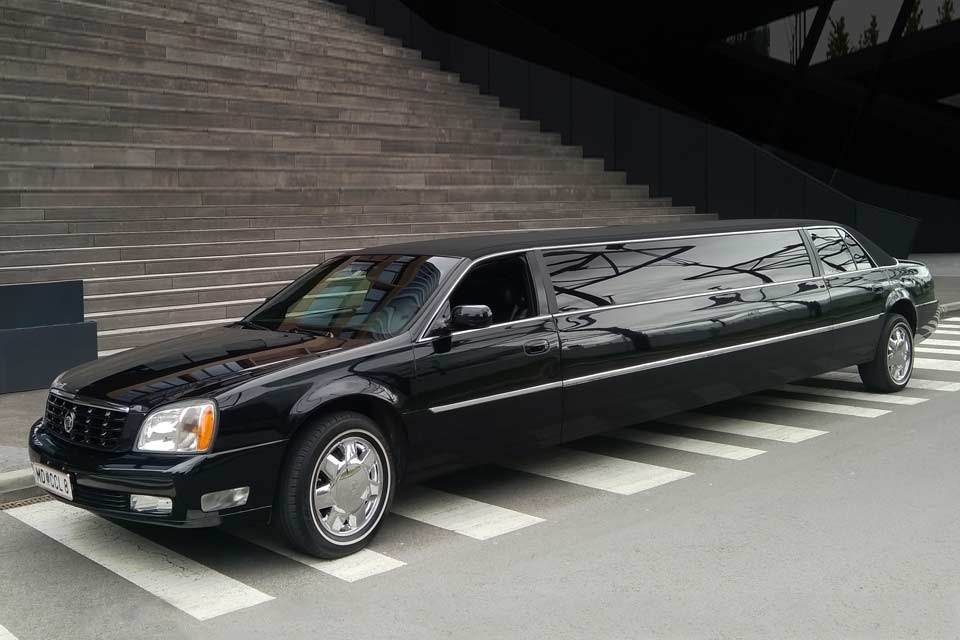 Black classic stretch limousine parked outside a venue